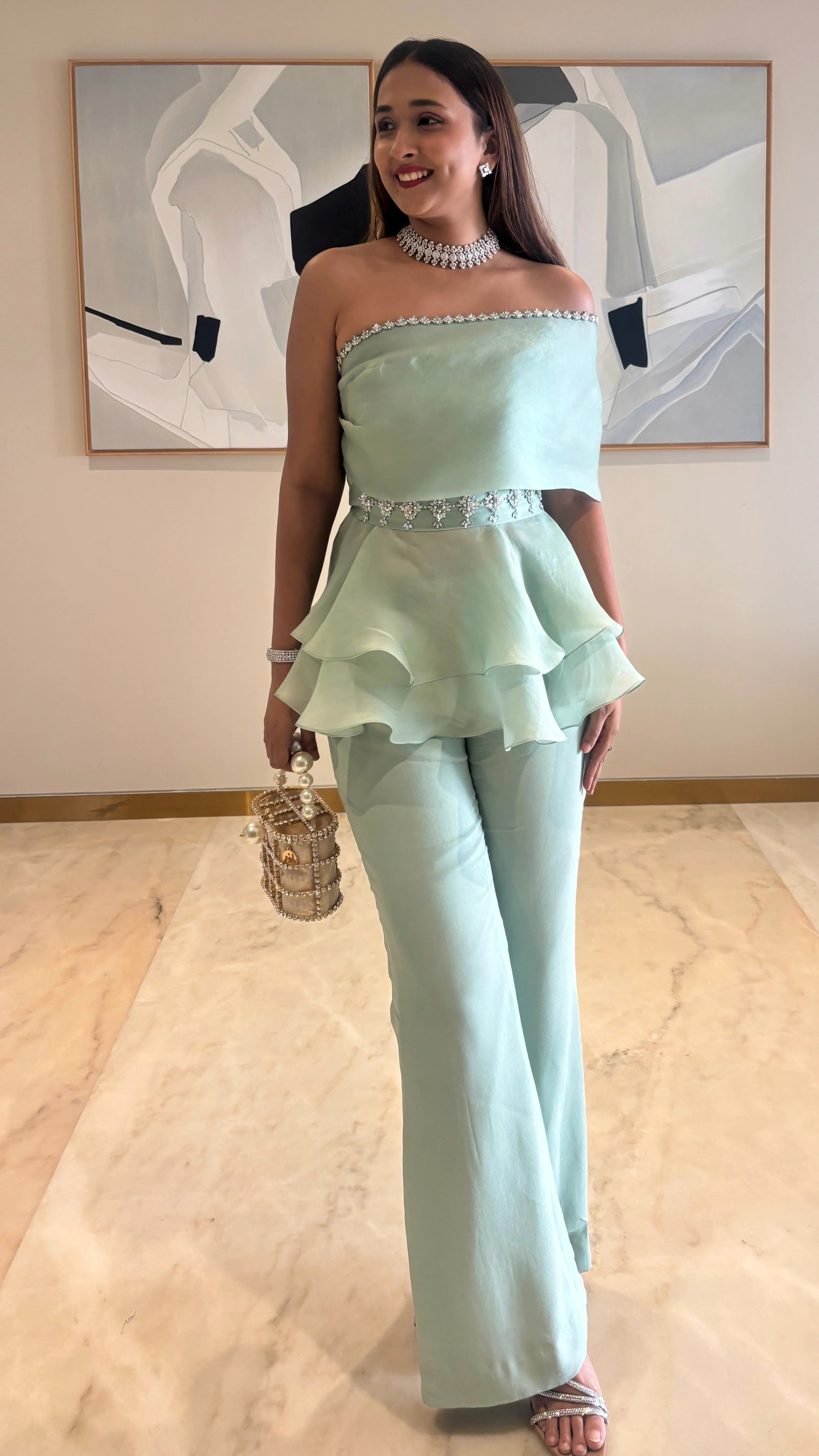 An intricately handcrafted embellished peplum top and pants.